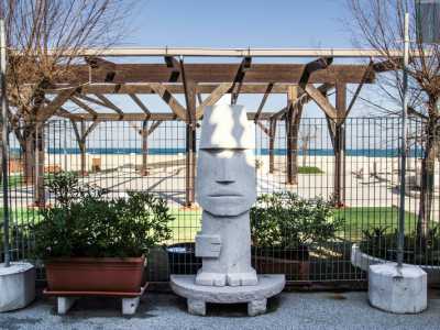 L�ampio spazio esterno che fronteggia l�ingresso principale del teatro, con piante ornamentali e una statua monolitica in tufo che riproduce un moai